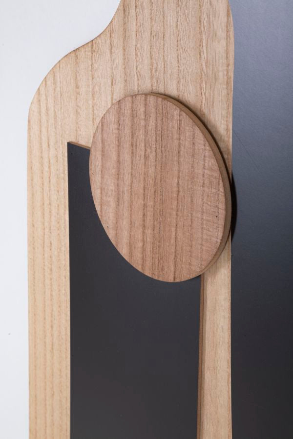Dettaglio del disco in legno a rilievo sopra il rettangolo nero del pannello ASTRY naturale #colore_Naturale
