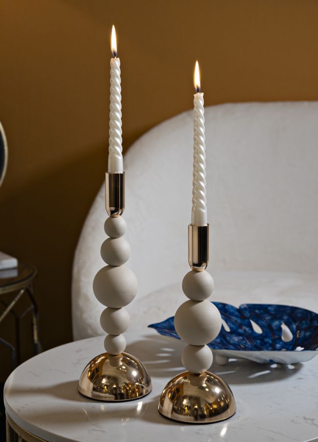 Portacandele BOLLY crema con candela accesa su tavolino bianco, ambientato in interno #colore_Crema