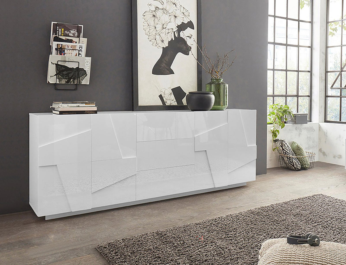 Credenza ambientata PULSE bianco lucido in soggiorno, vista tre quarti con quadro e libri sopra #colore_Bianco Lucido