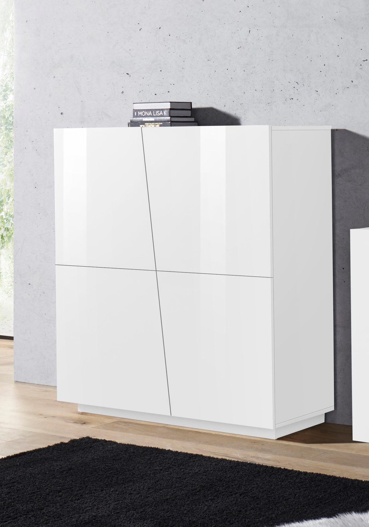 Credenza alta GALAXIA bianco lucido con quattro ante diagonali in ambiente interno con libri #colore_Bianco Lucido