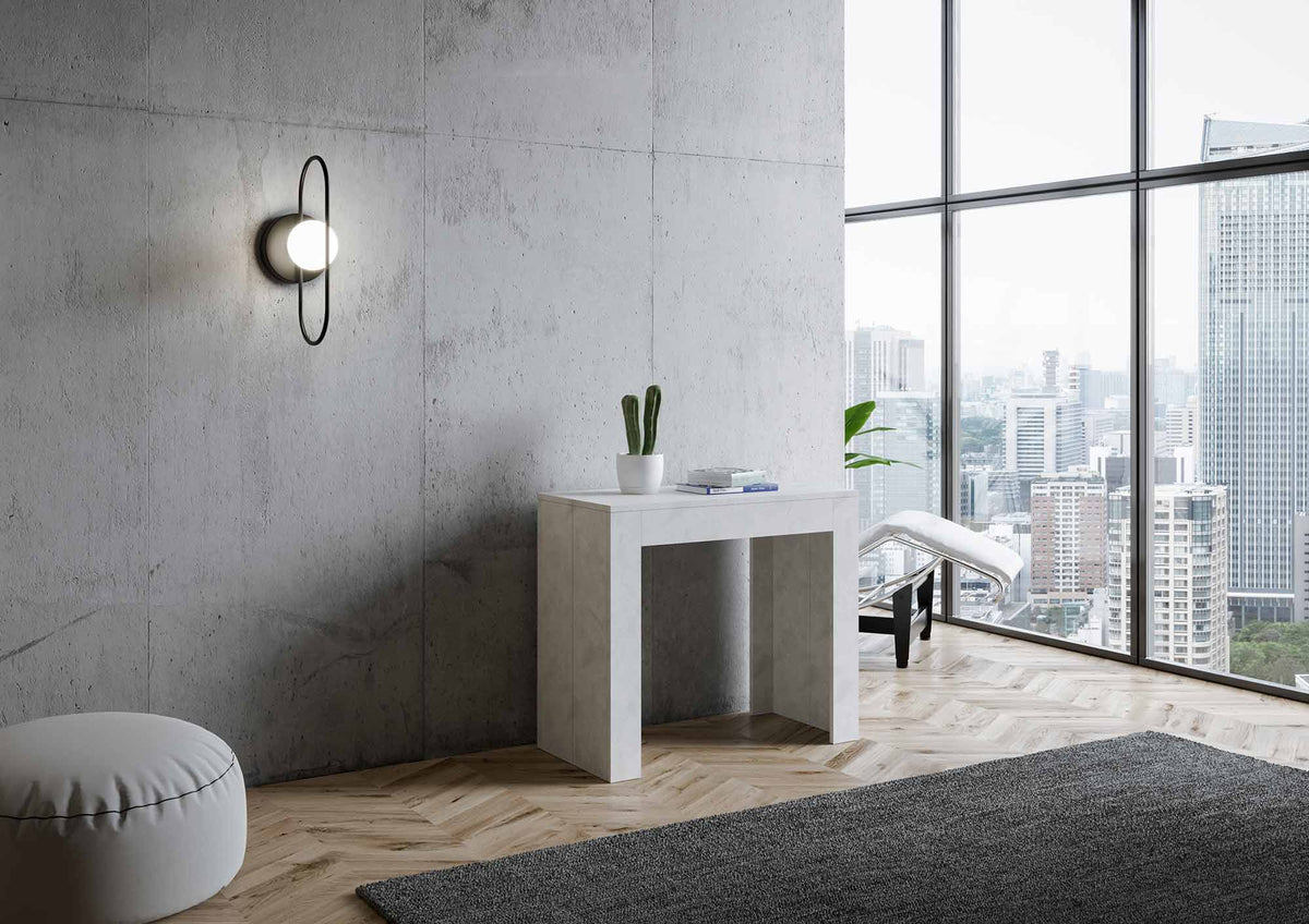 Consolle EMY SMALL bianco spatolato chiusa contro parete di cemento, vista tre quarti in ambiente #colore_Bianco Spatolato
