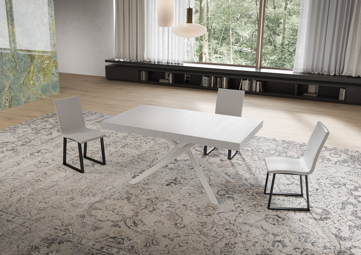 Tavolo NIKET bianco frassino chiuso con base a X, vista di tre quarti su tappeto grigio #colore_Bianco Frassino