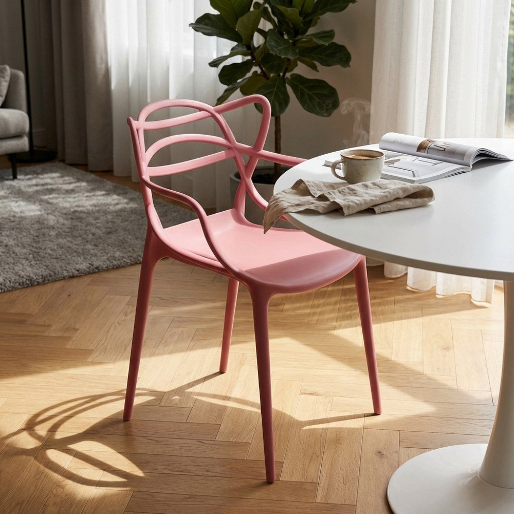Poltroncina LILY rosa con braccioli e schienale traforato in soggiorno, accanto a tavolino rotondo