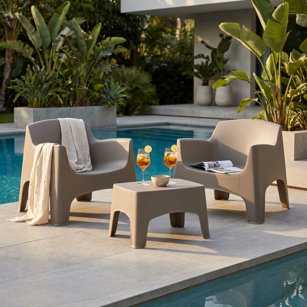 Poltrona IBIZA TERRACE taupe con coperta chiara, bordo piscina e piante sullo sfondo