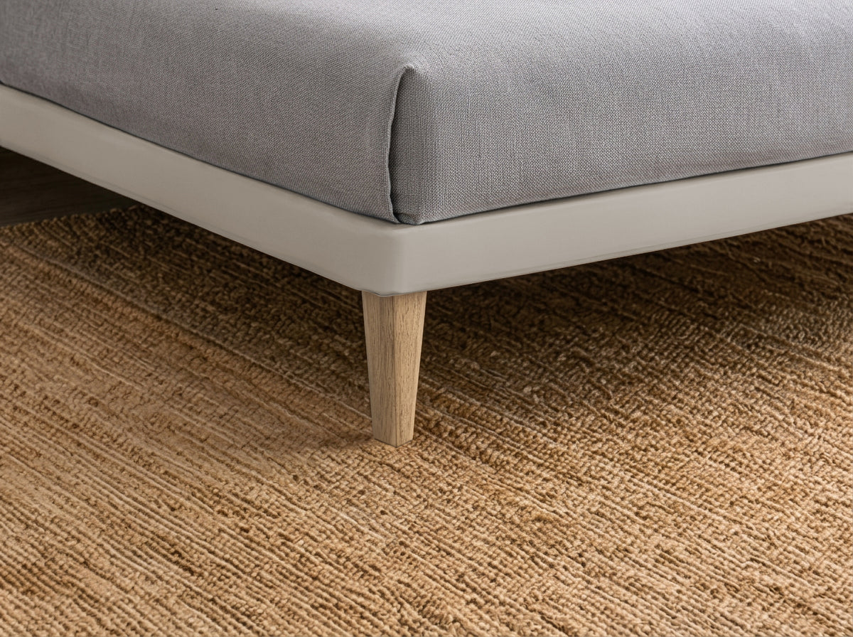 Dettaglio ravvicinato della base del letto SOFT tortora con gamba in legno naturale #colore_Tortora