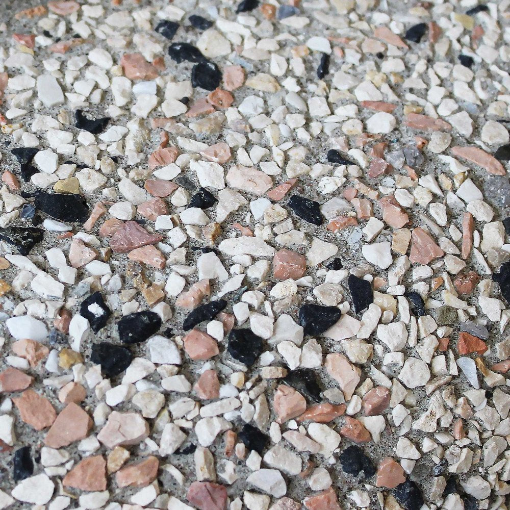Primo piano della superficie in ghiaino lavato con ciottoli bianchi, rosa, neri e grigi
