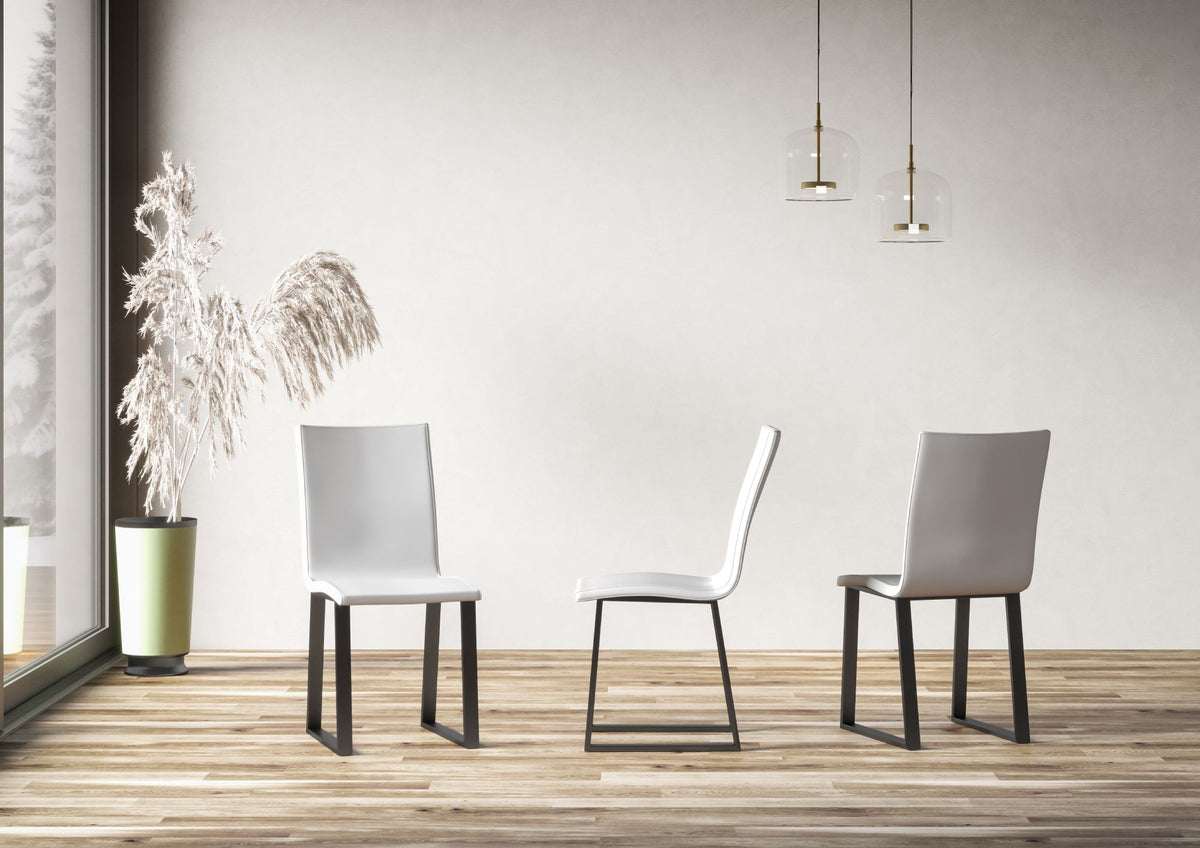 Tre sedie BAFFY bianche in una stanza con pavimento in legno, gambe scure #colore_Bianco