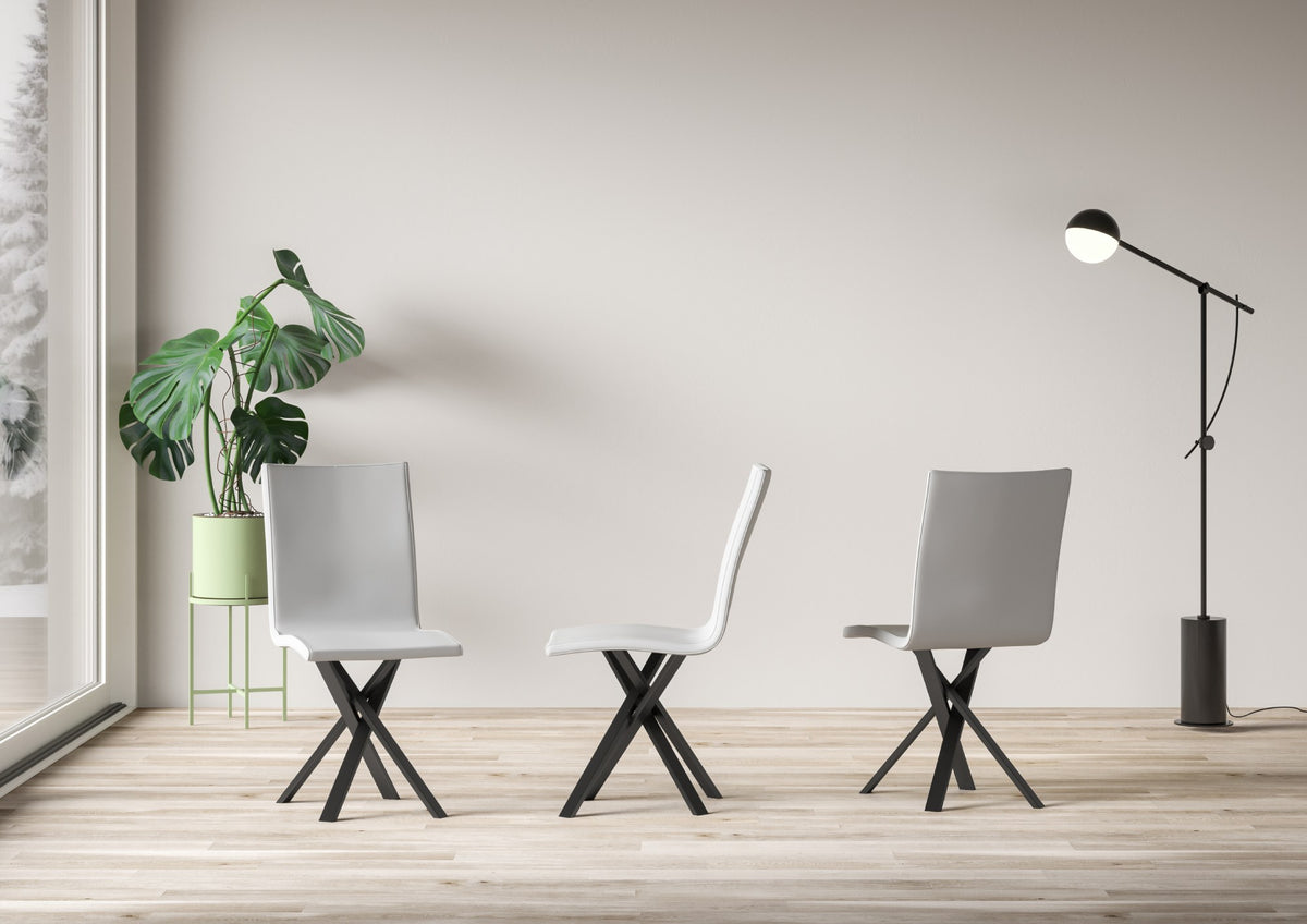 Sedia AURY bianca in ambiente con pianta monstera e lampada nera, vista tre quarti #colore_Bianco