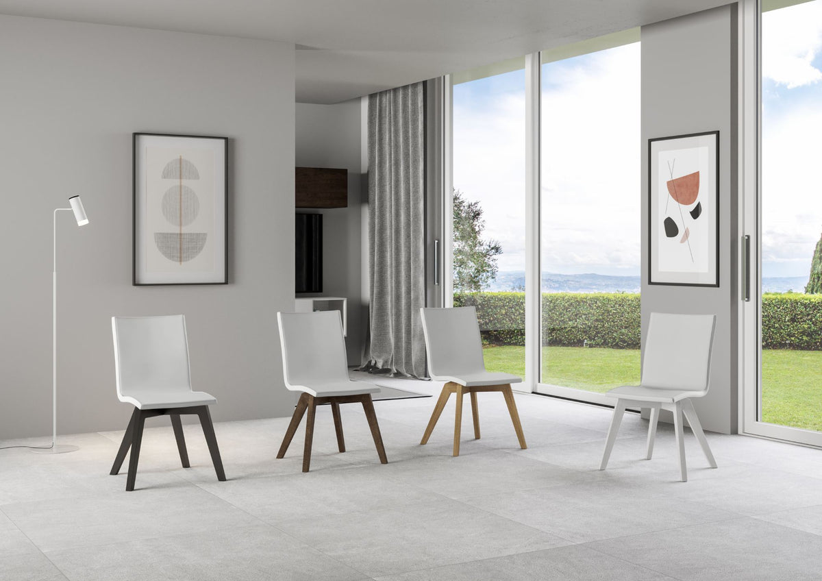 Quattro sedie TRUDY bianche con gambe diverse in una stanza luminosa, resa digitale #colore_Bianco