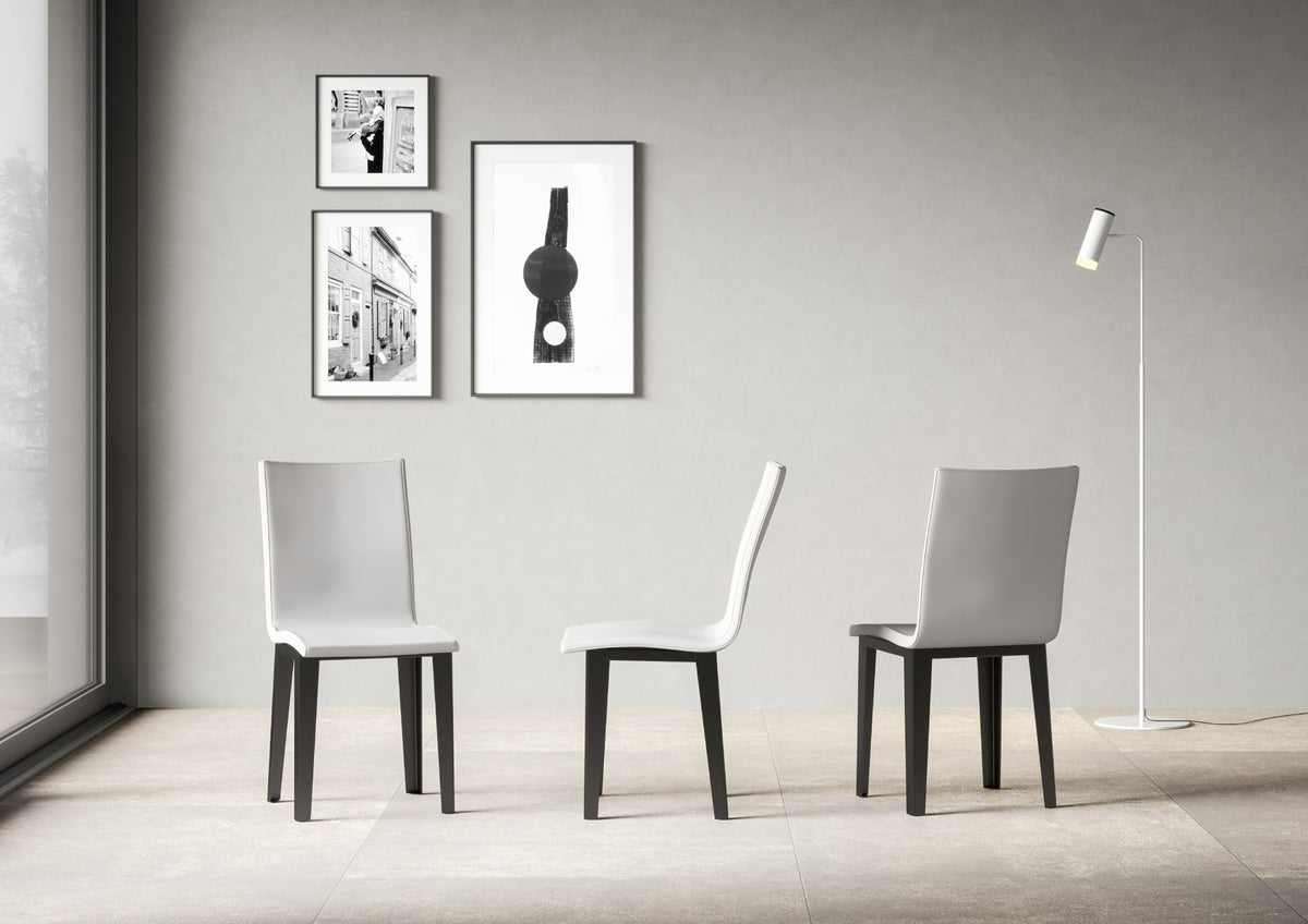 Tre sedie ARMIDA bianche in stanza, gambe antracite, vista frontale e laterale #colore_Bianco
