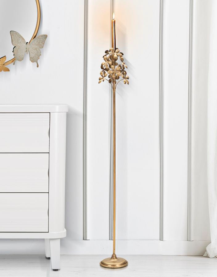 Portacandele da terra FLOWY oro con candela accesa in un interno con cassettiera bianca #dimensione_17x118
