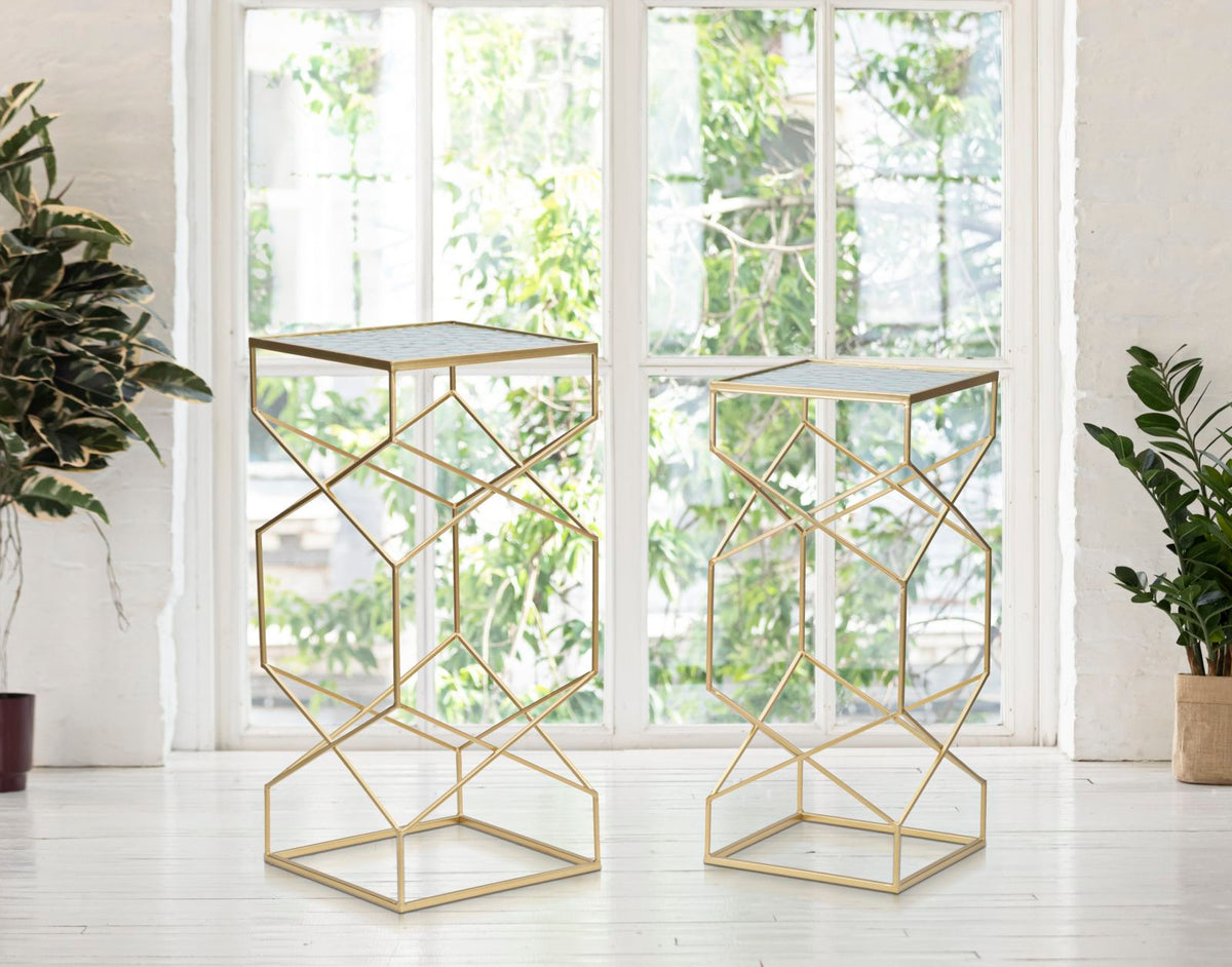 Tavolini GLASSY oro in salotto davanti alla finestra, accanto a due piante verdi in vaso #dimensione_H68