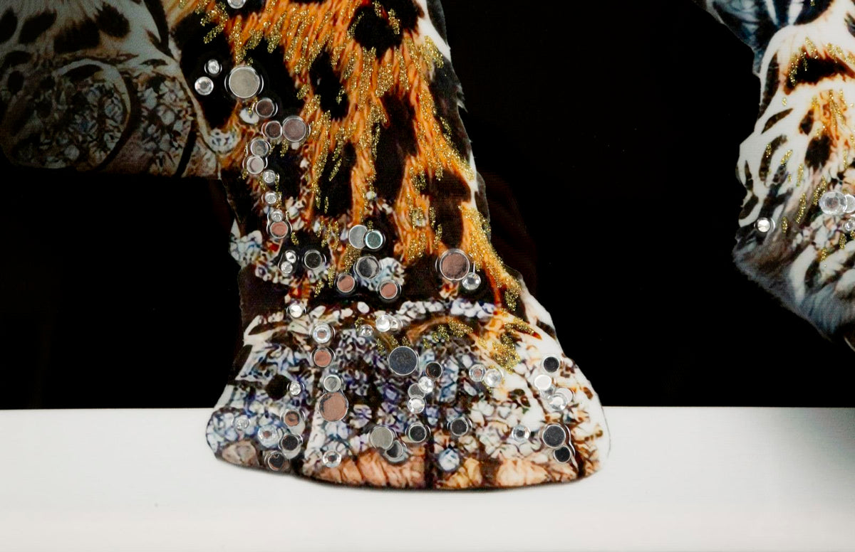 Dettaglio di GIAGUARO in tessuto con stampa animalier e applicazioni dorate, appoggiato su superficie bianca #colore_Multicolore