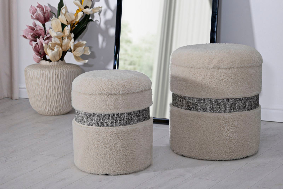 Pouf SAINT-MORITZ crema su pavimento chiaro in ambiente interno, accanto a un vaso con fiori #colore_Crema