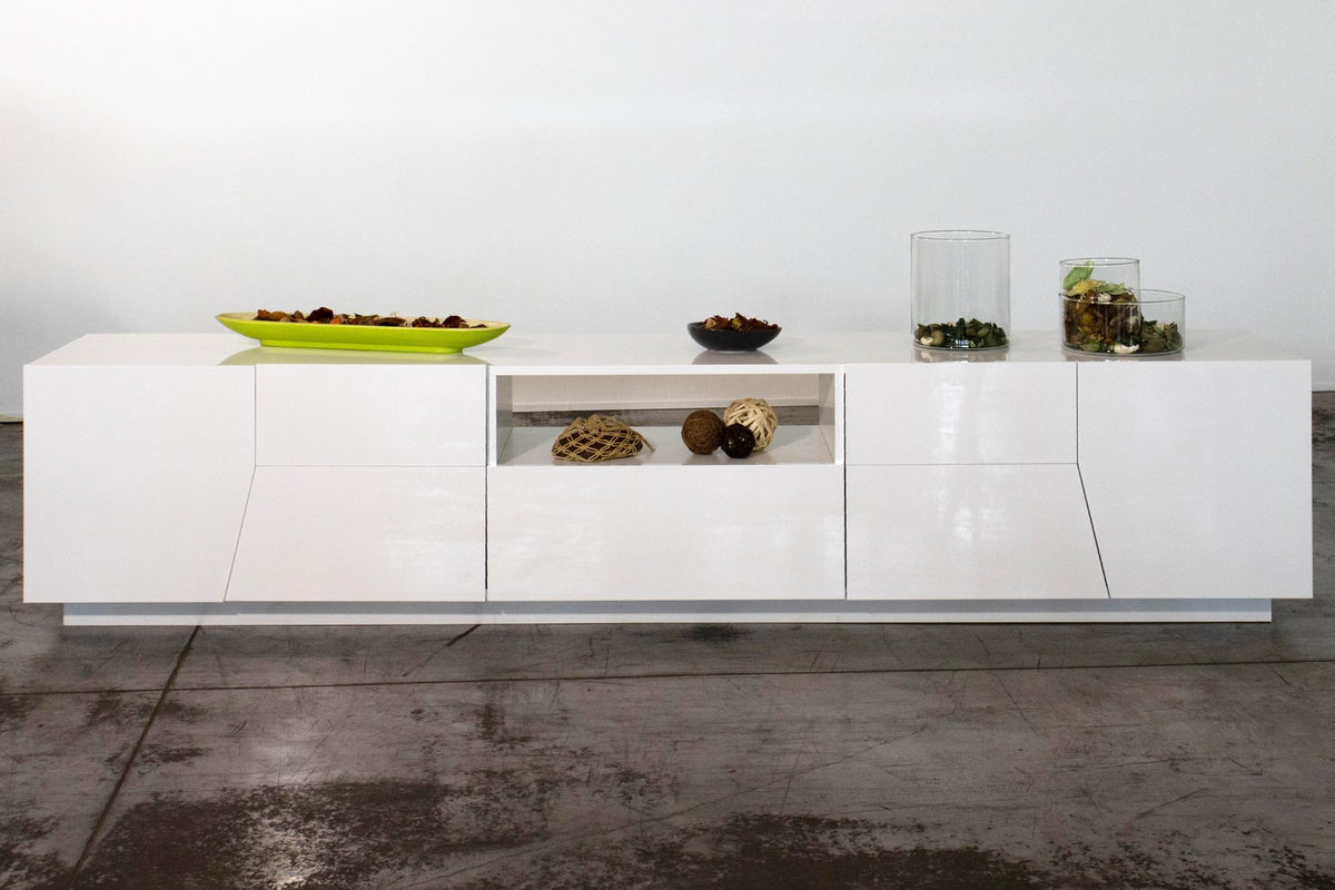 Porta TV NEBULA bianco lucido, vista frontale con vano centrale aperto e oggetti decorativi appoggiati #colore_Bianco Lucido