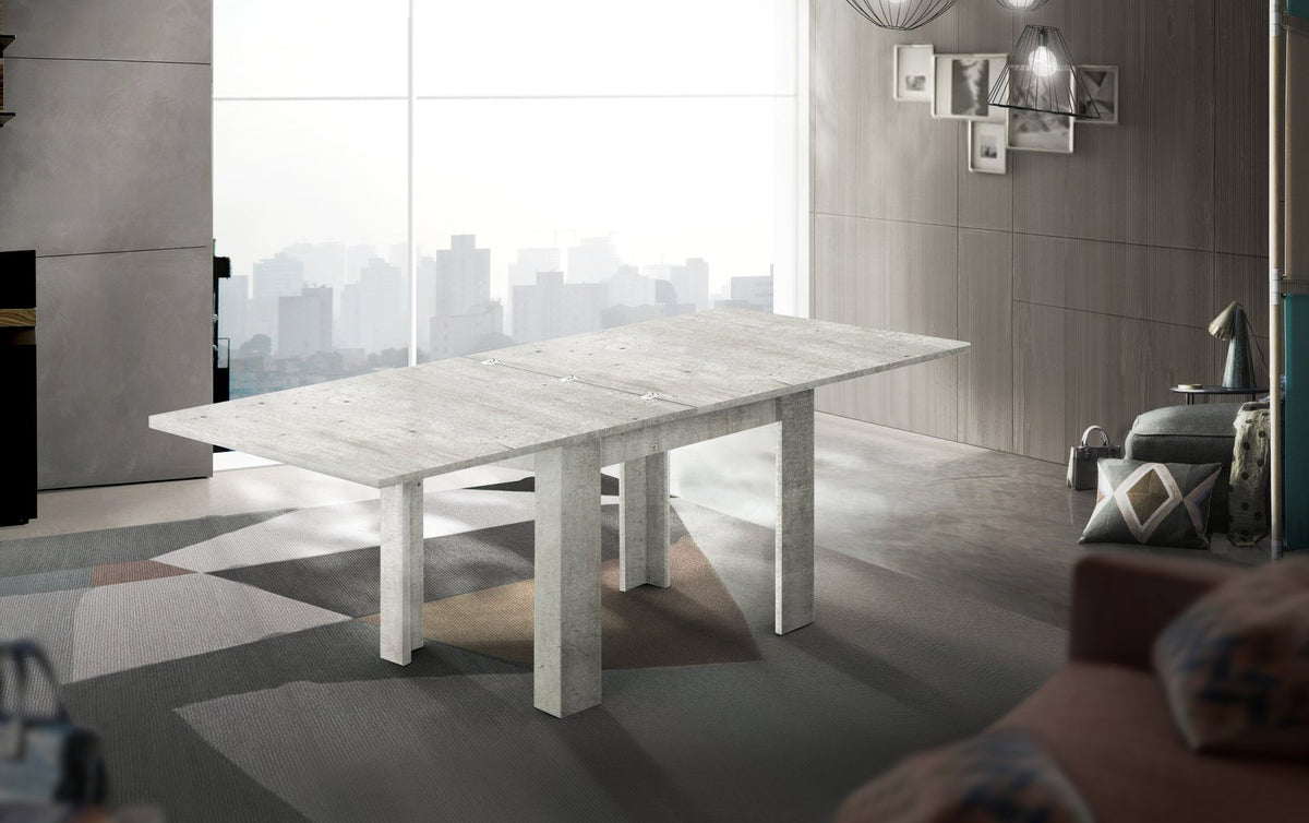 Tavolo LYRA bianco lucido e cemento allungato su tappeto grigio con divano sullo sfondo #colore_Bianco Lucido/Cemento