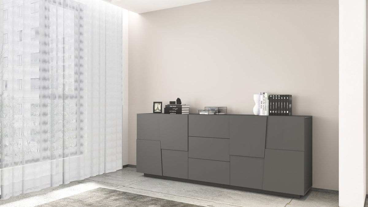 Credenza INFINITY antracite opaco in stanza beige, vista di tre quarti con oggetti di scena #colore_Antracite Opaco