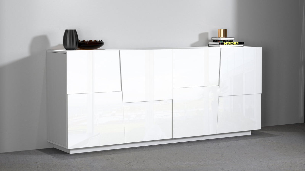 Credenza INFINITY bianco lucido appoggiata a parete grigia, con vaso e libri sul piano #colore_Bianco Lucido
