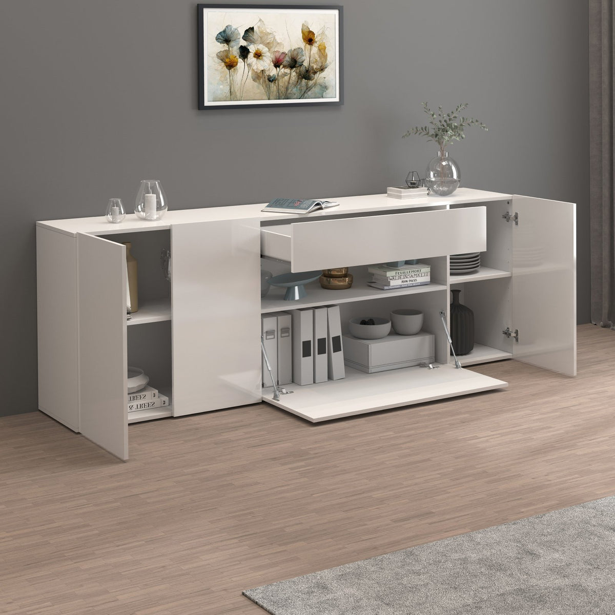 Credenza bianco opaco aperta in ambiente, ante spalancate e ripiani interni visibili