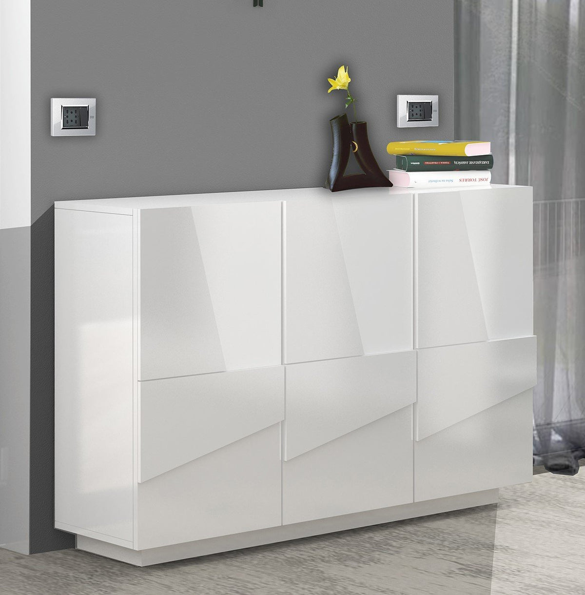 Mobile multiuso PULSE bianco lucido a tre ante, in soggiorno con vaso e libri sul piano #colore_Bianco Lucido