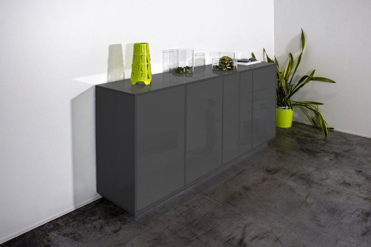 Credenza ENIGMA antracite opaco in ambiente interno, vista tre quarti con pianta verde a destra #colore_Antracite Opaco