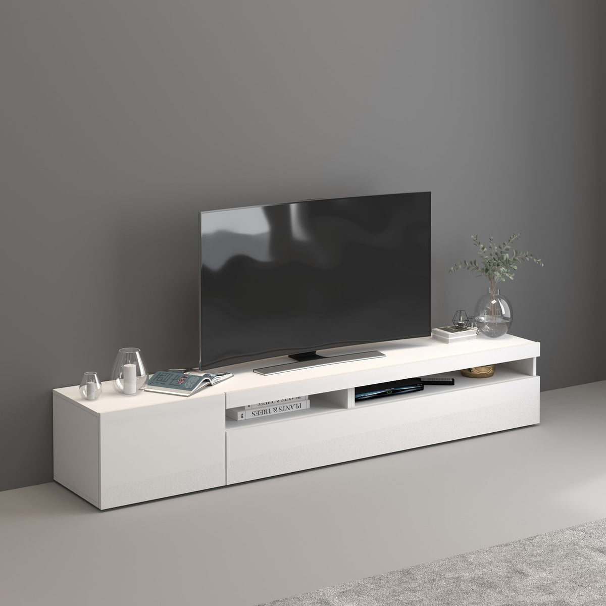 Porta TV bianco opaco in ambiente interno con vani a giorno e vasi decorativi sul piano