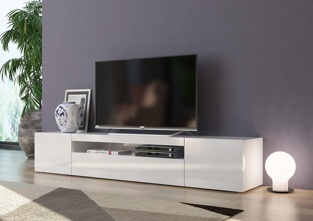 Porta TV FUSION bianco lucido contro parete viola con televisore e libro #colore_Bianco Lucido