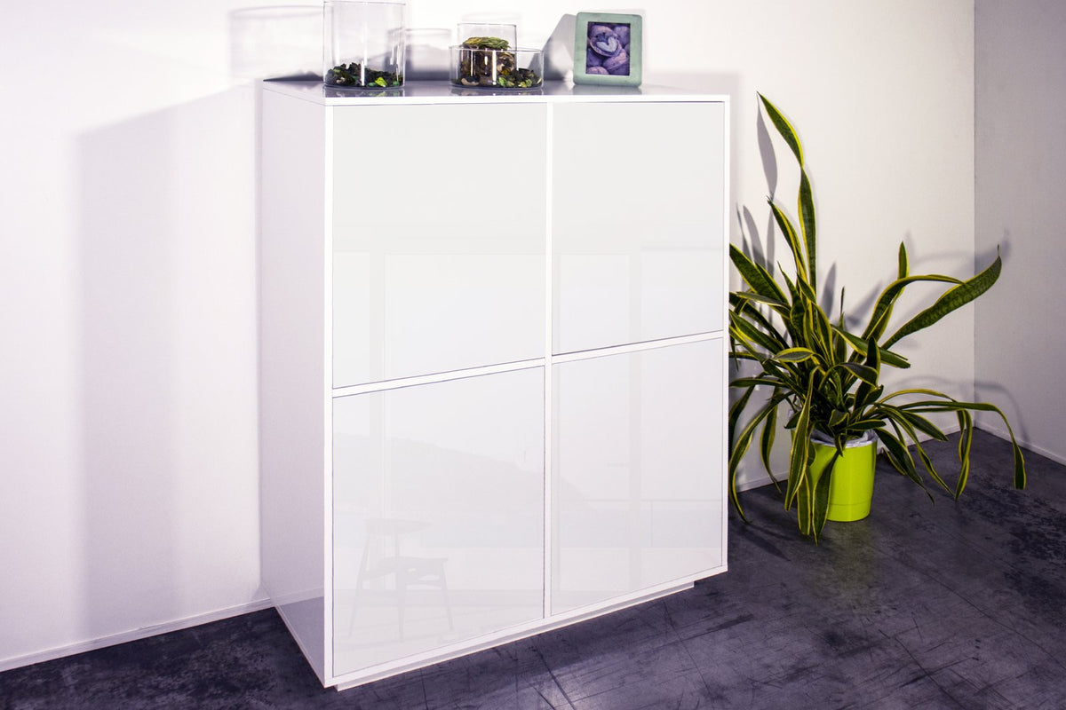 Credenza alta ENIGMA bianco lucido in ambiente interno, con vetrine e cornice sul piano