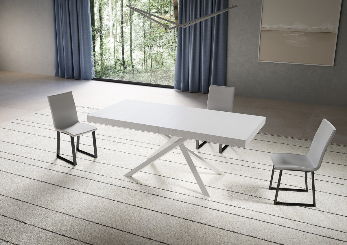 Tavolo NIKET bianco allungato con base a X bianca, su tappeto a righe bianche e nere #colore_Bianco Frassino