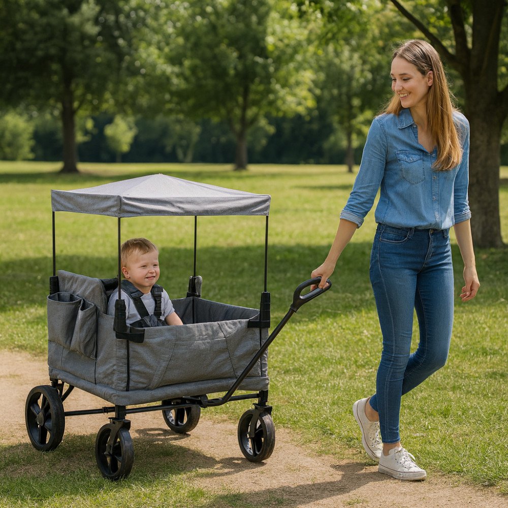 Carrello CARIBBEN grigio chiaro visto di lato con un bambino seduto dentro, su sentiero nel parco