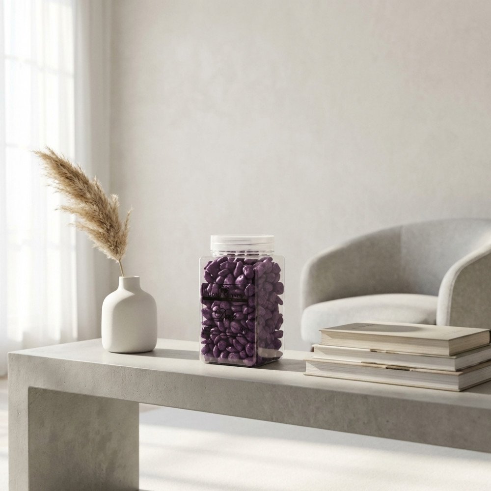 Barattolo di vetro con tappo bianco pieno di sassolini viola irregolari arrotondati, vista tre quarti