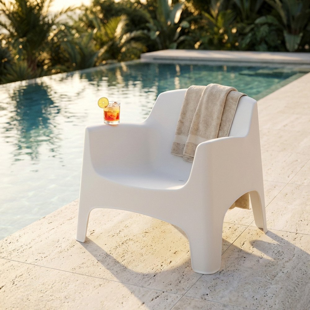 Poltrona da esterno IBIZA bianca in ambiente con piscina e piante tropicali sullo sfondo