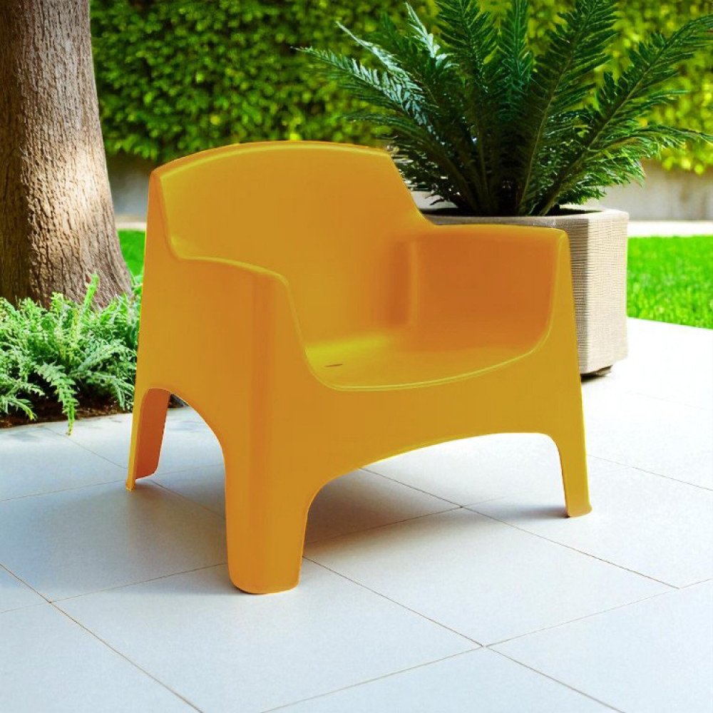 Poltrona monoblocco IBIZA giallo in giardino su piastrelle chiare, tra siepi e fioriera
