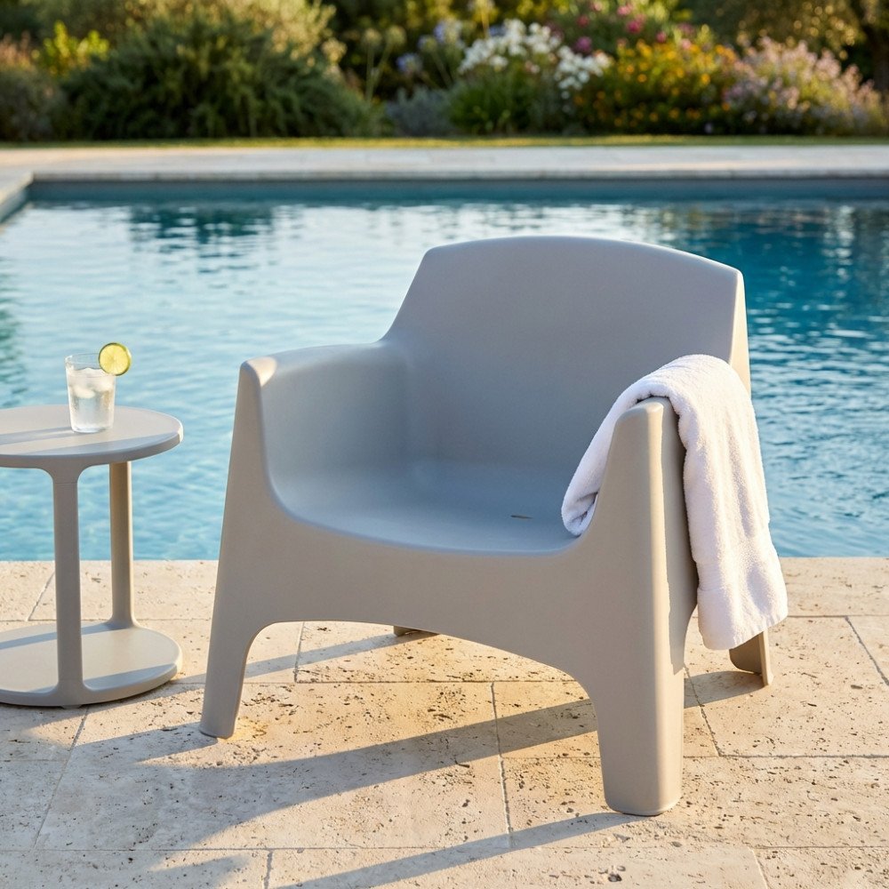 Poltrona IBIZA grigio chiaro di tre quarti sul pavimento in pietra, vicino alla piscina