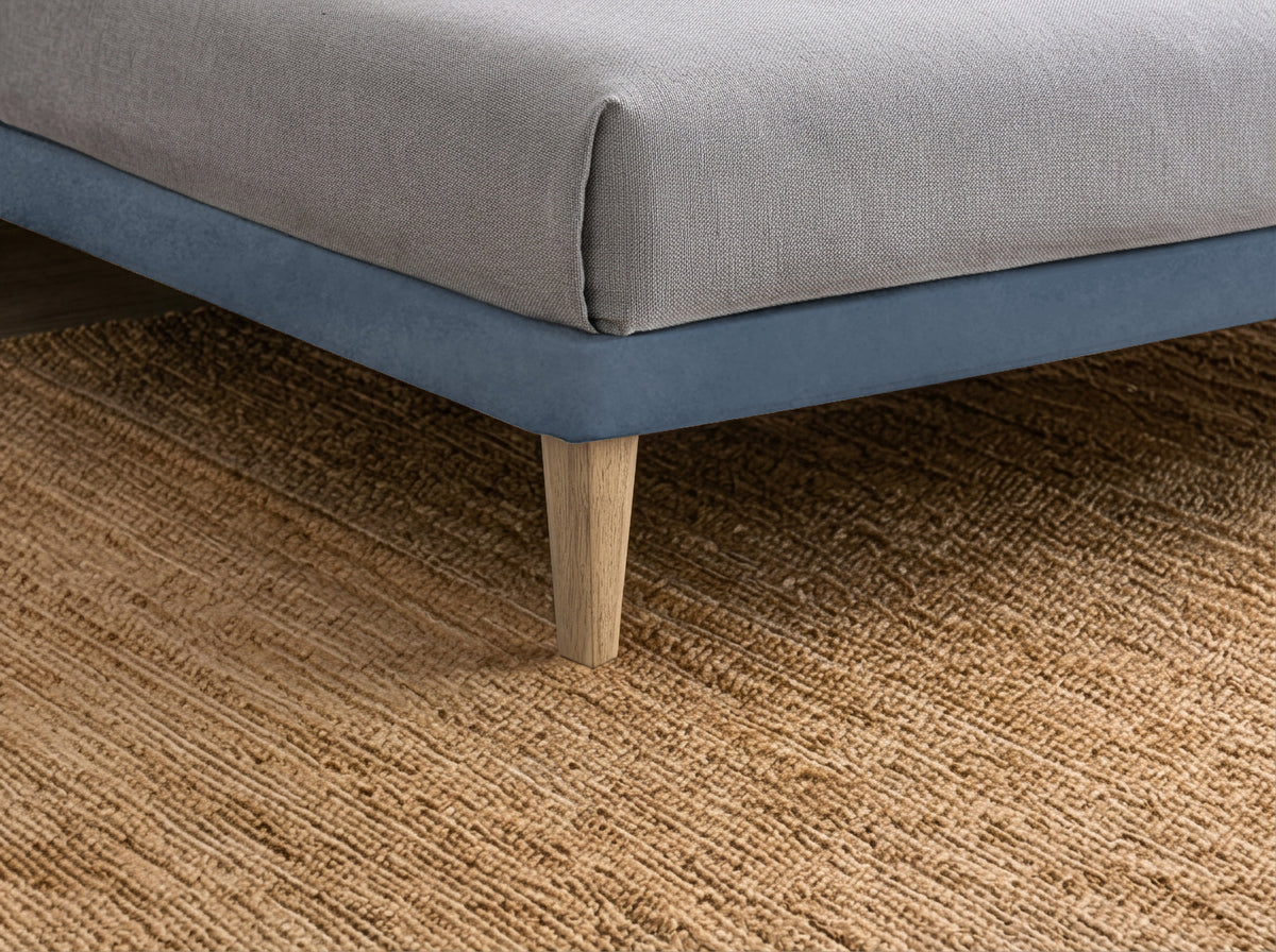Dettaglio ravvicinato del basamento del letto FLAT blu con gamba in legno chiaro #colore_Blu