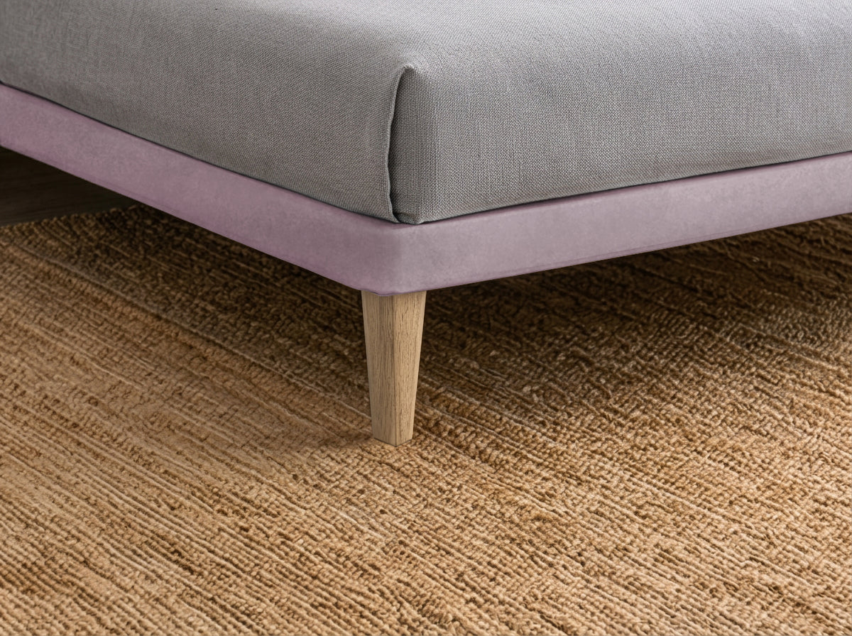 Dettaglio ravvicinato dell'angolo inferiore del letto FLAT glicine con gamba in legno naturale #colore_Glicine