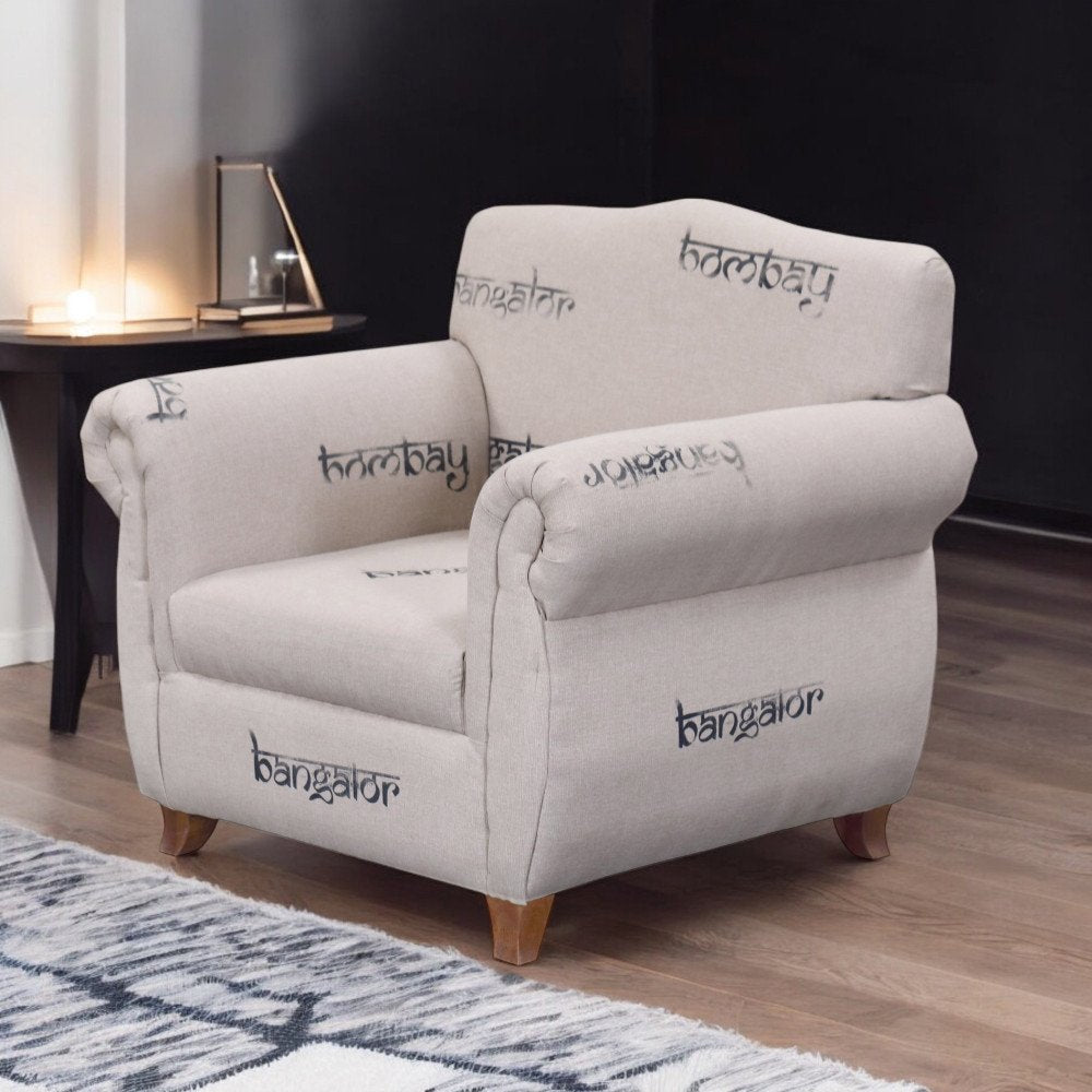 Poltrona DESTINY beige con braccioli imbottiti davanti a parete scura e tappeto a motivi