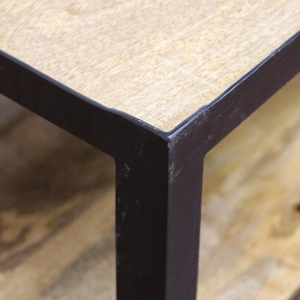 Dettaglio dell'angolo del piano in legno chiaro del tavolino MARLOW marrone, graffi sul bordo nero