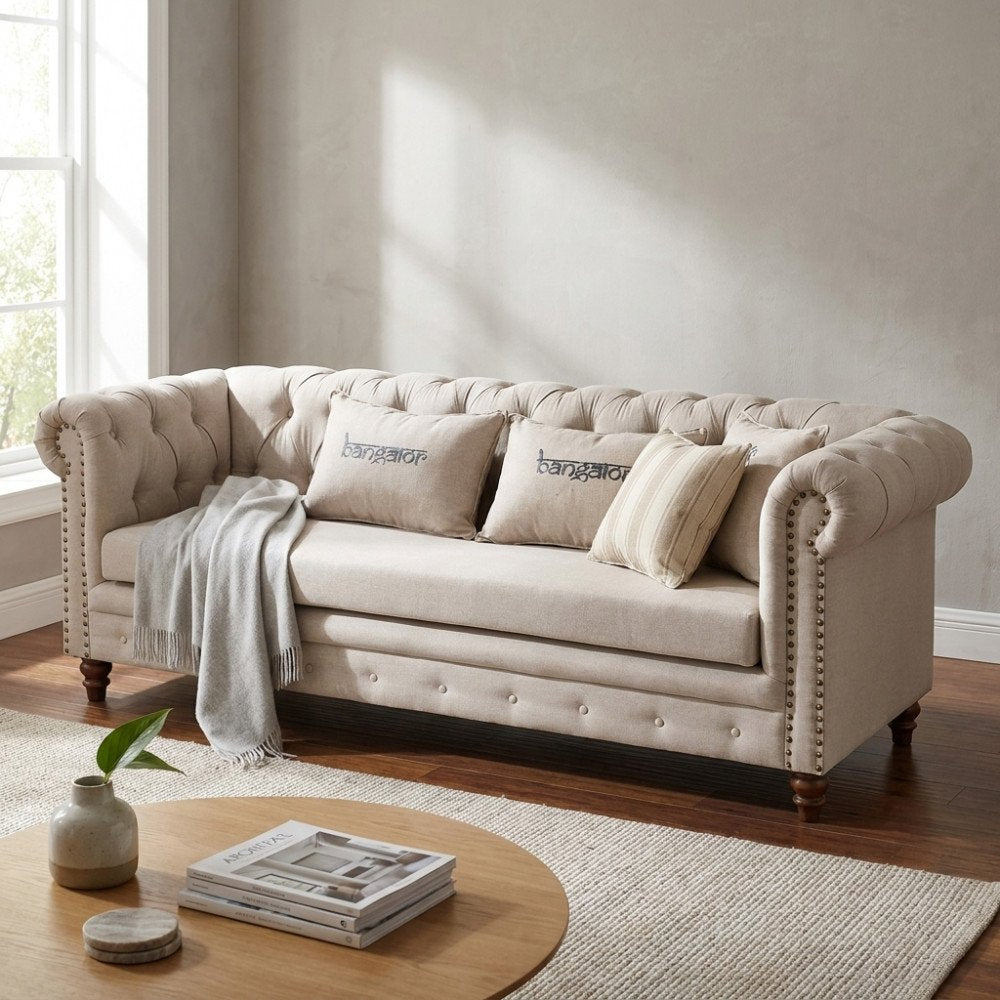 Divano MERCER beige a tre posti con braccioli arrotolati e borchie decorative