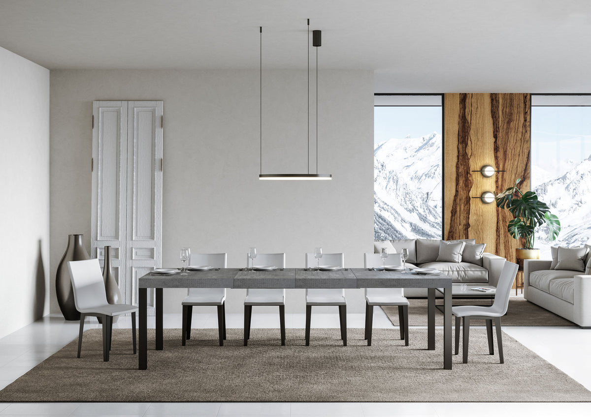 Tavolo EVERYDAY PREMIUM cemento in posizione allungata ripreso frontalmente con sei sedie bianche #colore_Cemento