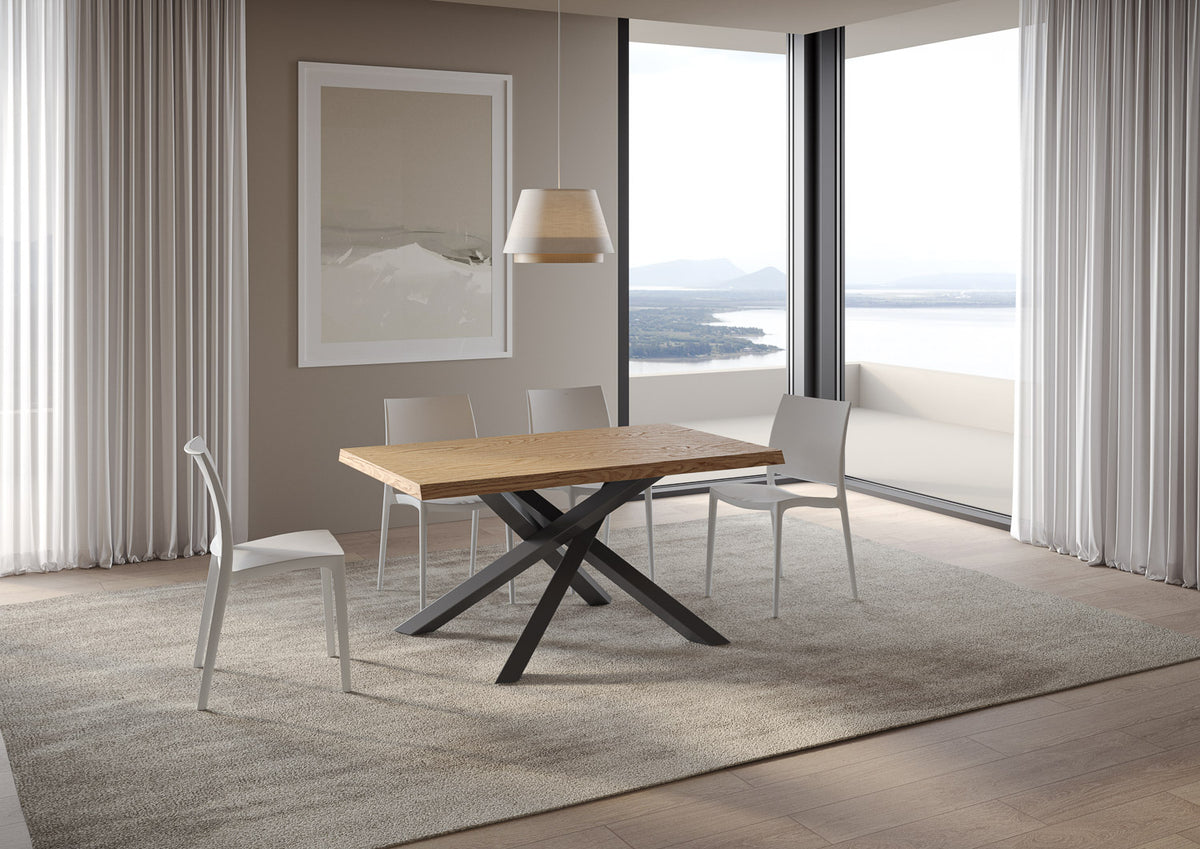 Tavolo da pranzo VERSALUX rovere con gambe a X nere in sala luminosa con sedie bianche