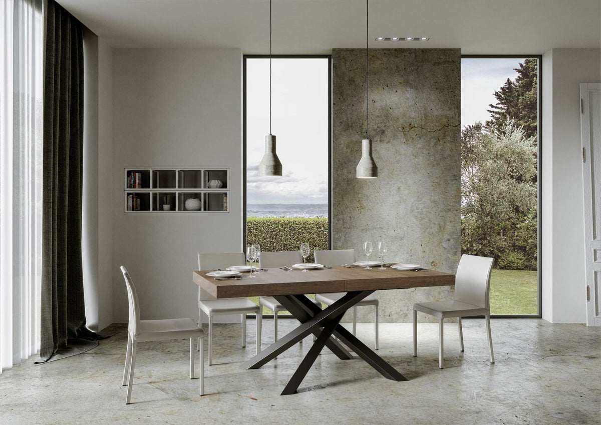 Tavolo VOLANTIS noce chiuso con base a croce antracite in sala con vista sul mare #colore_Noce
