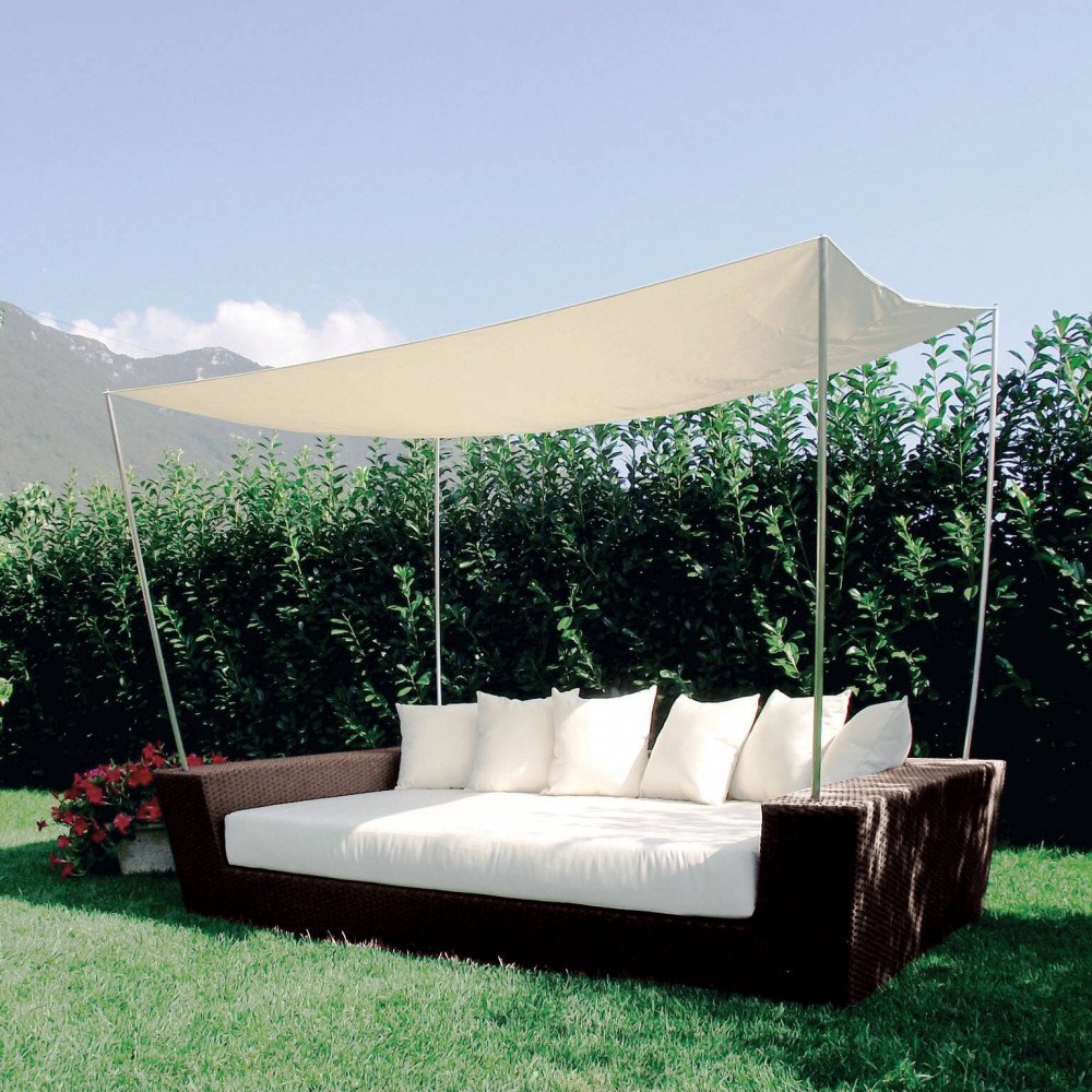 Divano SHADDY marrone con materassino bianco panna e cuscini sullo schienale, vista laterale in giardino